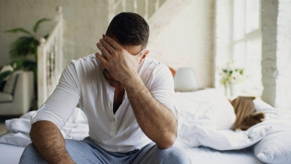 Klonopin Side Effects hero image of a man experiencing nausea and a headache.