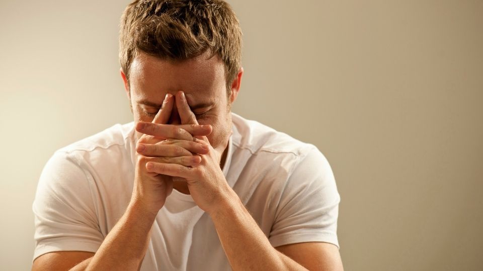 Can You Overdose on Kratom hero image of a man holding his head in clasped hands